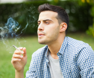 Young Man Smoking a Cigarette Outdoors