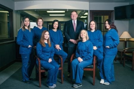 The team at Goebel Family Dentistry. Photo of 6 women smiling and Dr. Goebel smiling.