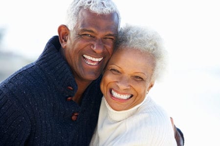 Happy older couple smiling, showing their beautiful white teeth