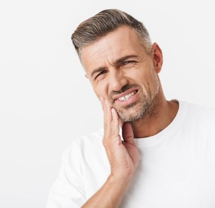 Man holding the side of his face, portraying dentist cannot find source of toothache