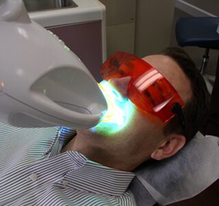 Tooth whitening patient under a zoom whitening light