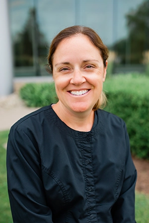 Close up a woman, Darcy, smiling. She is a Hygienist