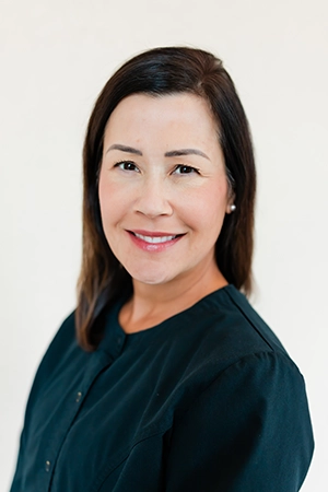 Close up of a smiling woman named Jenny. She is a Hygienist