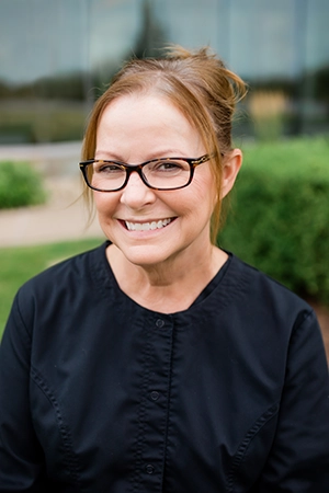 Close up of a woman, Shawn, smiling. She is a Hygienist