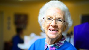 An elderly woman smiling.